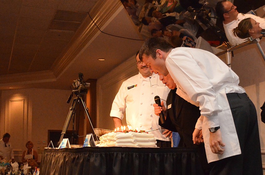 Fr. Fausto Stampiglia and Fr. Sebastian Szczawinski blow out the candles.