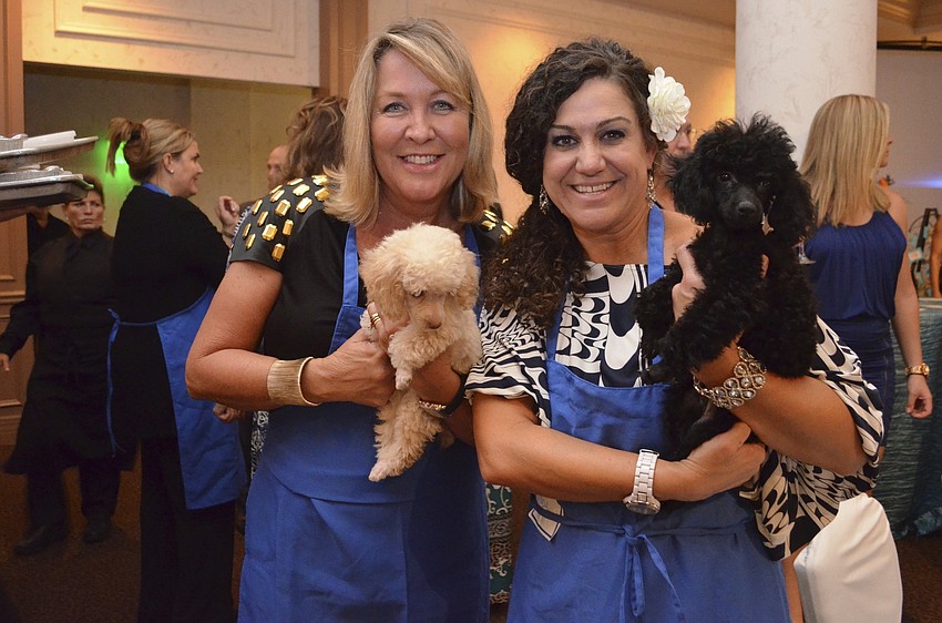 Robin Turner and Tracy Fox with poodles Saint and Martha, live auction items donated by Dr. Ninaâ€™s.
