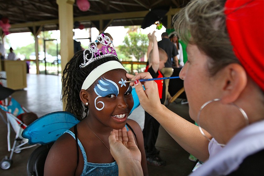 Aaliyah, 10, has her face painted by Lisa Singeisen