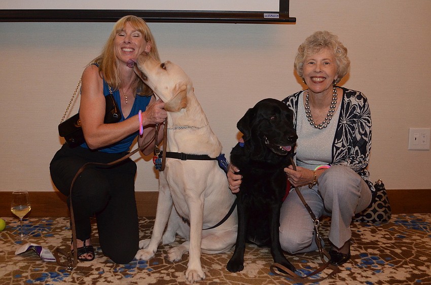 Susan Tone with her yellow lab Millard and Mary-Lou Moulton with her black lab Miss Fay