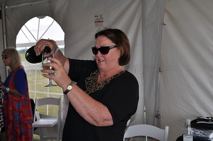 Kathy Tams pouring wine at Sundayâ€™s Sip and Soar event.