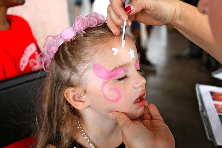Vivian Hugill, 3, has her face painted.
