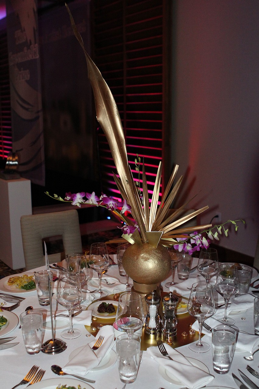 The centerpieces were made out of cantaloupes and palm fronds spray painted gold with orchids added for a pop of color.