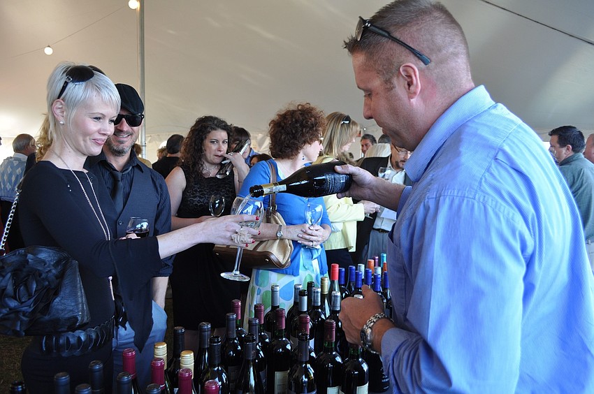 Diane Wurst has her glass filled by Zach Raymond with Republic National