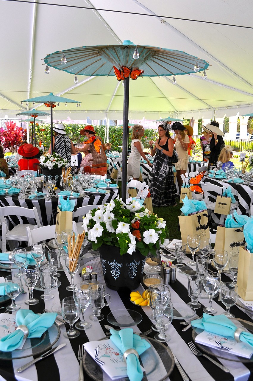 The centerpieces included a decorative pot with white flowers and a turquoise parasol decorated with jewels and butterflies.