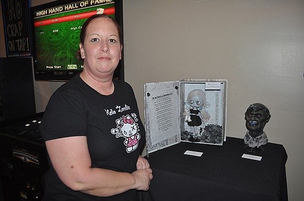 Kat Oster poses near her work (left).