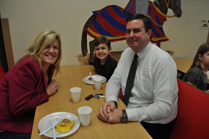 Monica, Ty, 7, and Kevin Moore feast on a pancake breakfast at Tara Elementary School. The event awarded Tara's 90 students who earned straight A's. Principal Steve Royce even cooked the pancakes.
