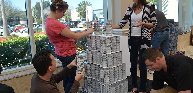 Tim Borden, Dana Haise, Brianne Allen and Scott Gross work on their can creation of the Empire State Building.