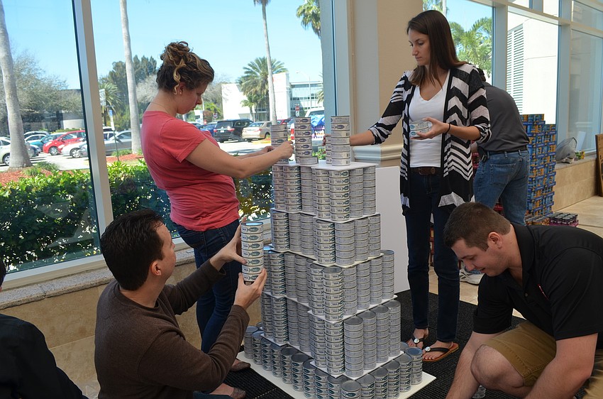 Tim Borden, Dana Haise, Brianne Allen and Scott Gross work on their can creation of the Empire State Building.