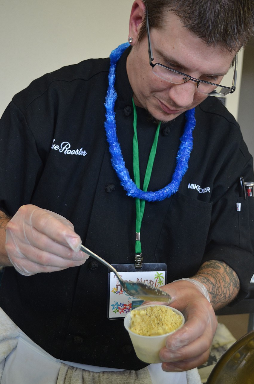 Mike Yoder or Blue Rooster hands outs smoked Gouda mac and cheese.