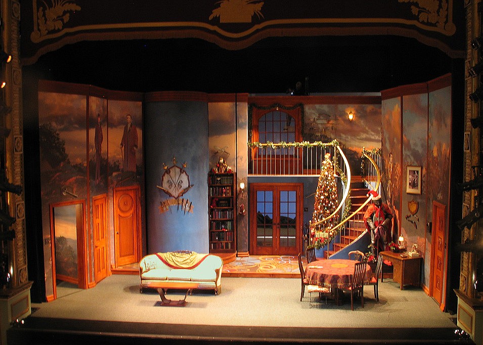 The set as it appears on stage, as designed by Judy Gailen. The blue portion of the wall is on a turret and transforms into a hidden bar. Courtesy photo.