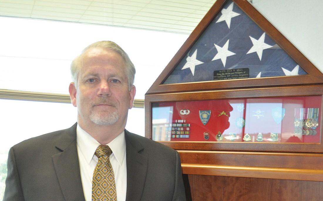 Rick Mills hung his unit colors and coins from his time in the military in his office.