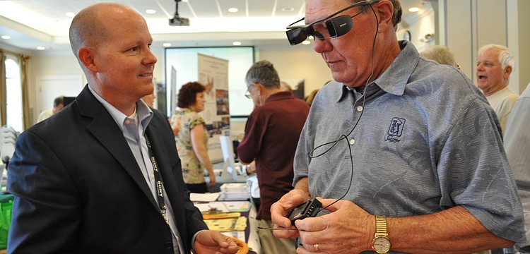 Sony representative Chris Simpson showed off new movie-watching technology for the hearing impaired to George Rochow.