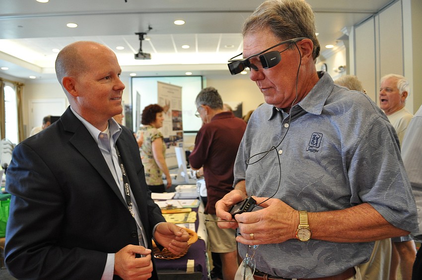 Sony representative Chris Simpson showed off new movie-watching technology for the hearing impaired to George Rochow.