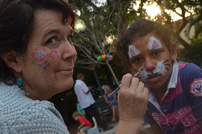 Martha Hafner paints Maleah Moyaâ€™s face.