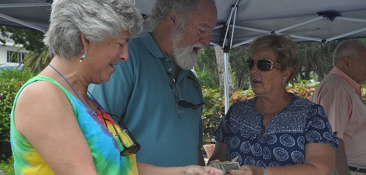 Reina Berman and Bob Krosney buy a bracelet from Carol Rebert