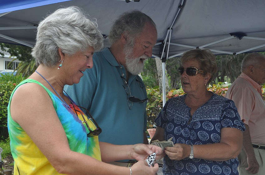 Reina Berman and Bob Krosney buy a bracelet from Carol Rebert