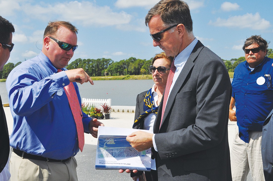 FISA Executive Director Matt Smith, right, flips through Sarasota/ManateeÃ¢â‚¬â„¢s bid, which SunCoast Aquatic Nature Center Association, including Paul Blackketter, left, of Benderson Development, submitted.
