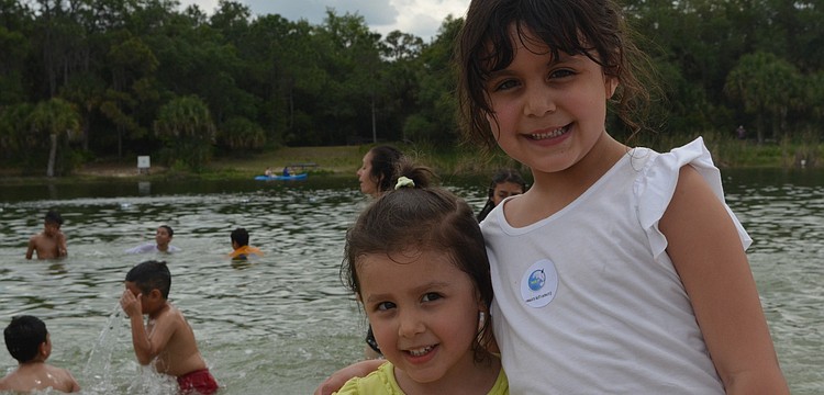 Sisters Allison and Isabel Dunn dip their feet in the lake to cool off.