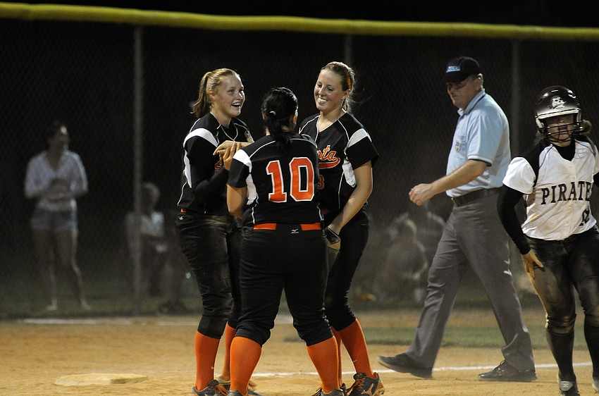 Sarasota third baseman Sarah Beth Wengerd, pitcher Clarissa Lynch and shortsop Halie Roberson celebrate following Wengerdâ€™s tag in the bottom of the sixth inning.
