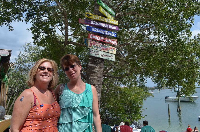 Cathy Minter and Wendy Holmberg enjoy the afternoon at Casey Key Fish House. Minter has a blue ribbon temporary tattoo to show her support during National Child Abuse Prevention month.