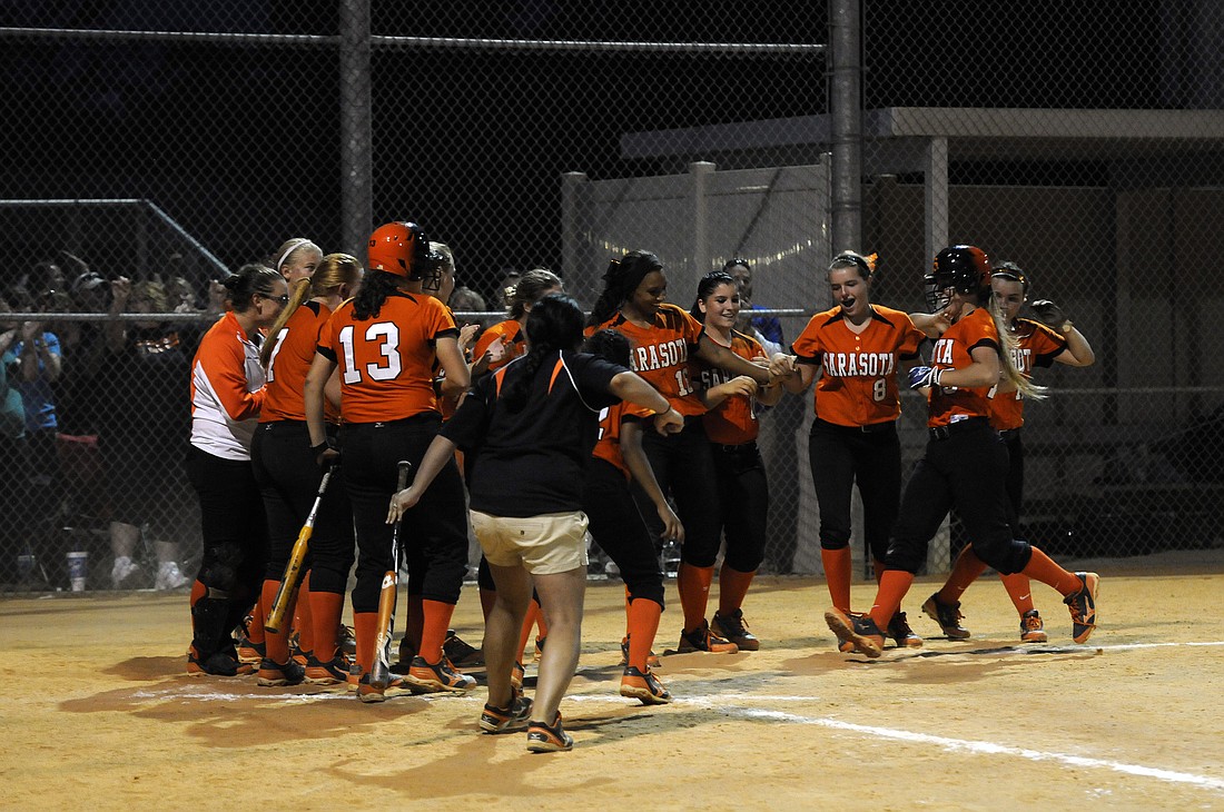 The Sarasota High softball team celebrates following Alyssa Price's solo home run with two outs in the top of the seventh inning.