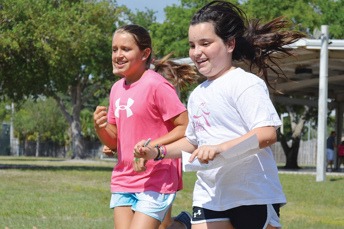 Lilly Dougherty, right, runs the track with a friend at Phillippi Shores Elementary School in preparation for the upcoming Girls on the Run 5K Saturday, May 4, at Nathan Benderson Park.
