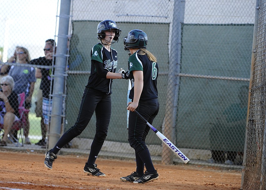 Sierra Schappacher and Shea Fisher celebrate after Schappacher scored a run in the bottom of the sixth inning.