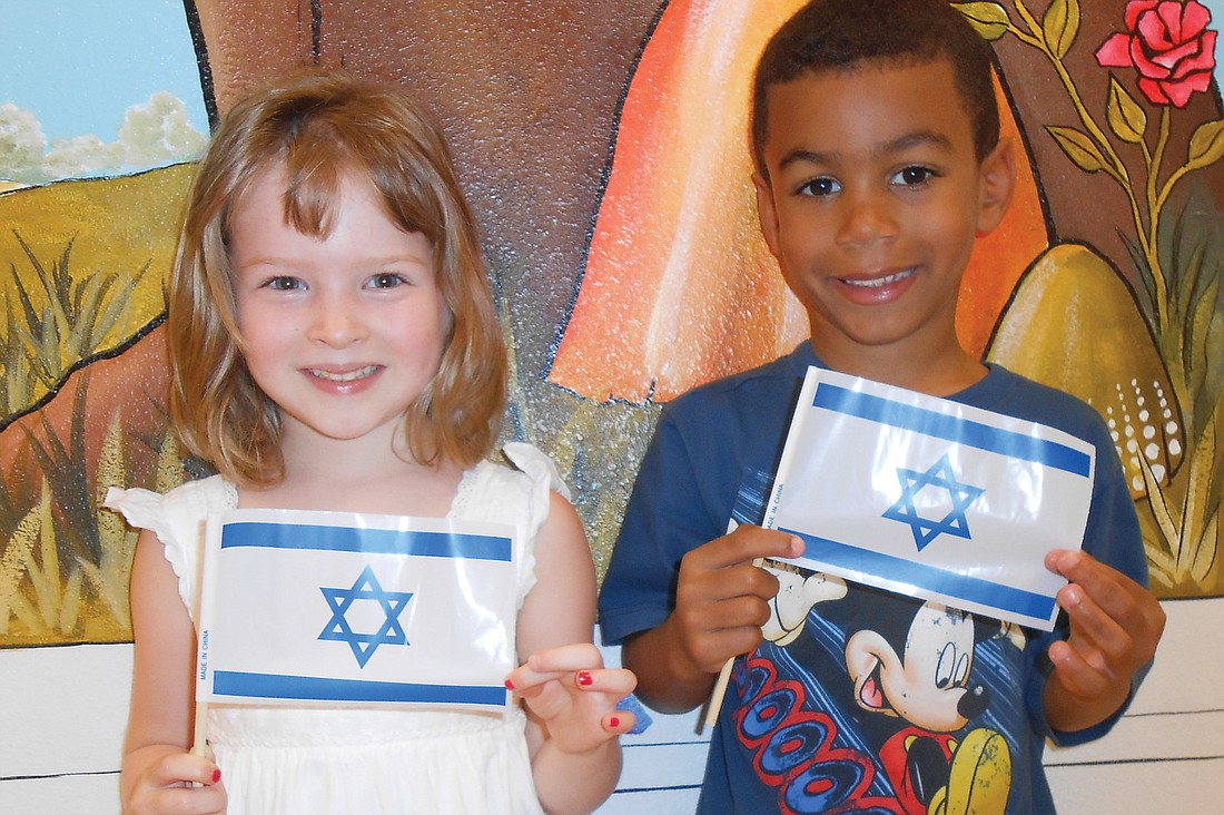 Sasha Nir and Matthew Baker wave flags to celebrate IsraelÃ¢â‚¬â„¢s 65th birthday. Courtesy photo