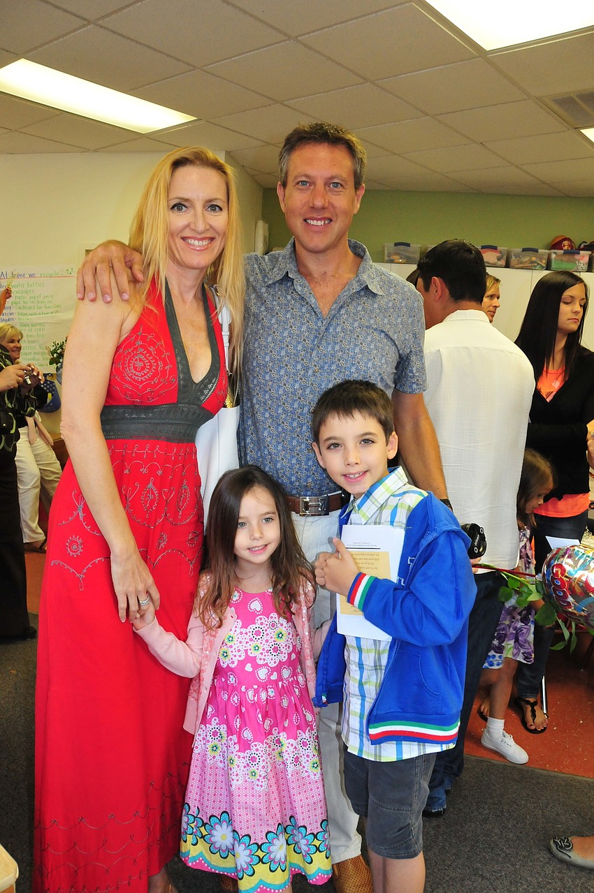 After her Pre-Kindergarten graduation, Victoria Mochkovsky, accompanied by her family, proudly smiles for the camera.