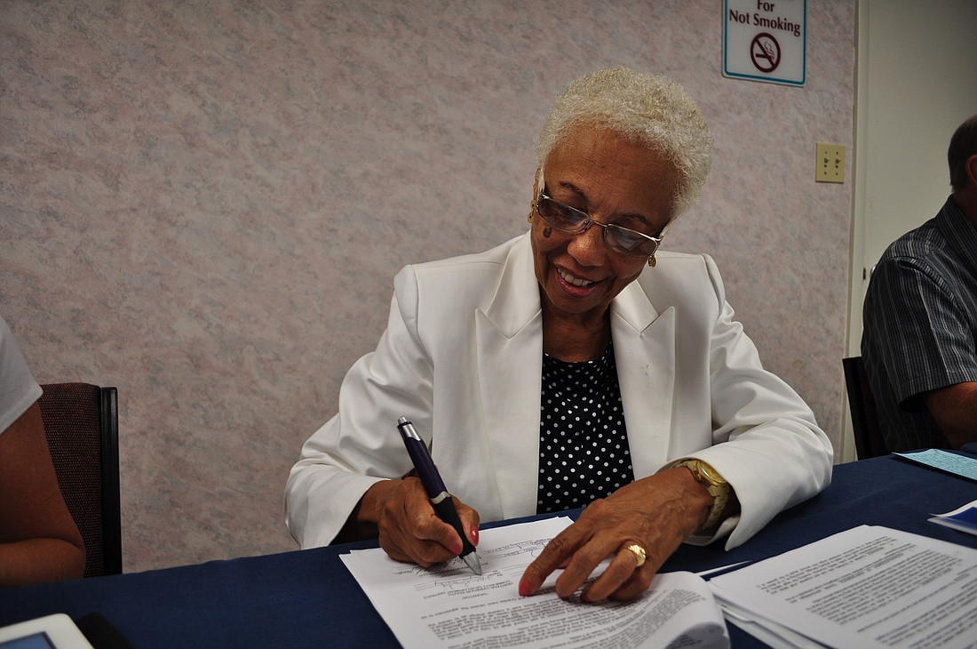 Heritage Harbour South CDD Chairwoman Joyce Sandy signs the settlement agreement.