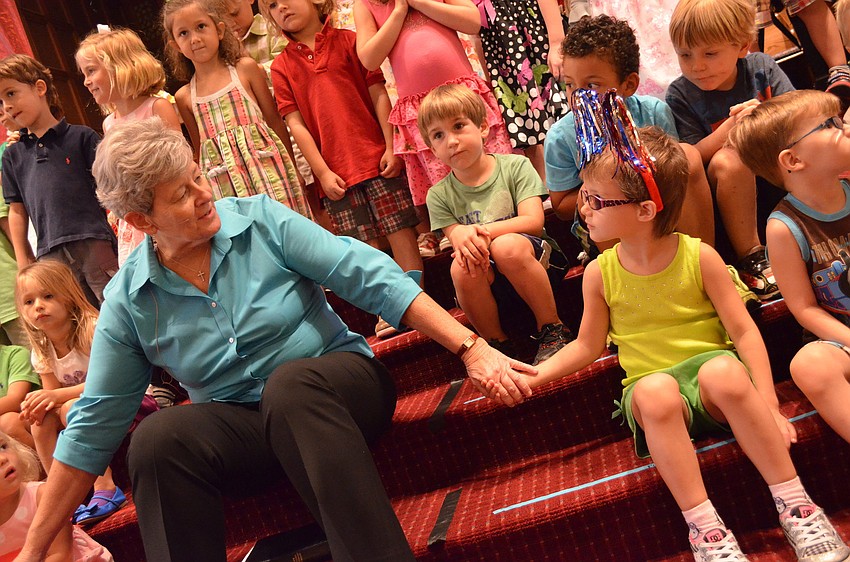 Pastor Kathy Dain holds Isabelle Faucherâ€™s hand and thanks God for the wonderful children.