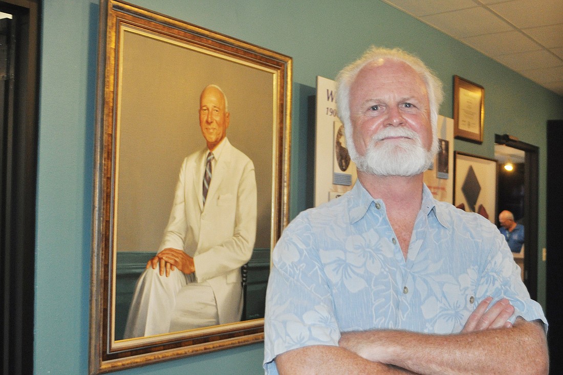 Dr. Michael Crosby stands in front of a portrait of the late William Mote, whose support helped to transform the laboratory.