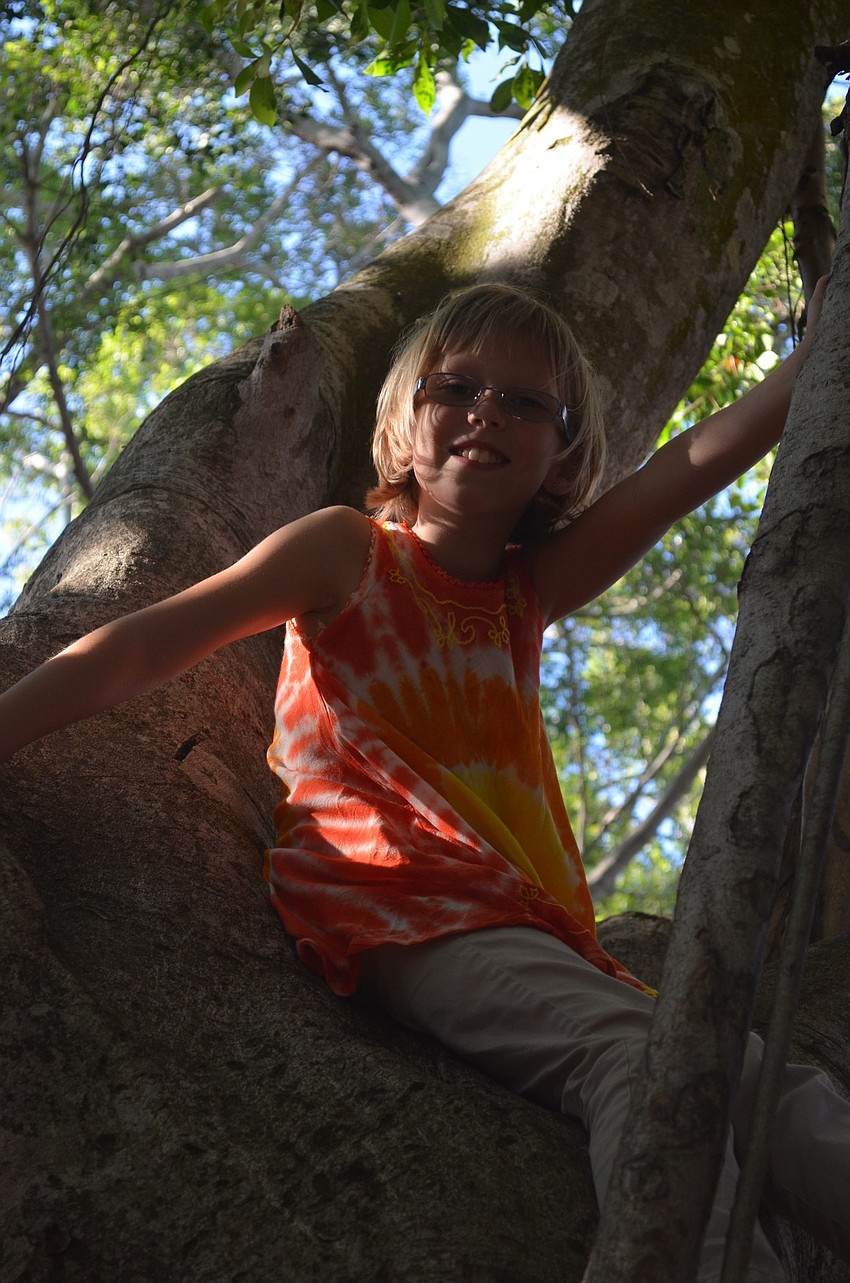 Lily V. climbs a tree during the Crossing the Mulch celebration.