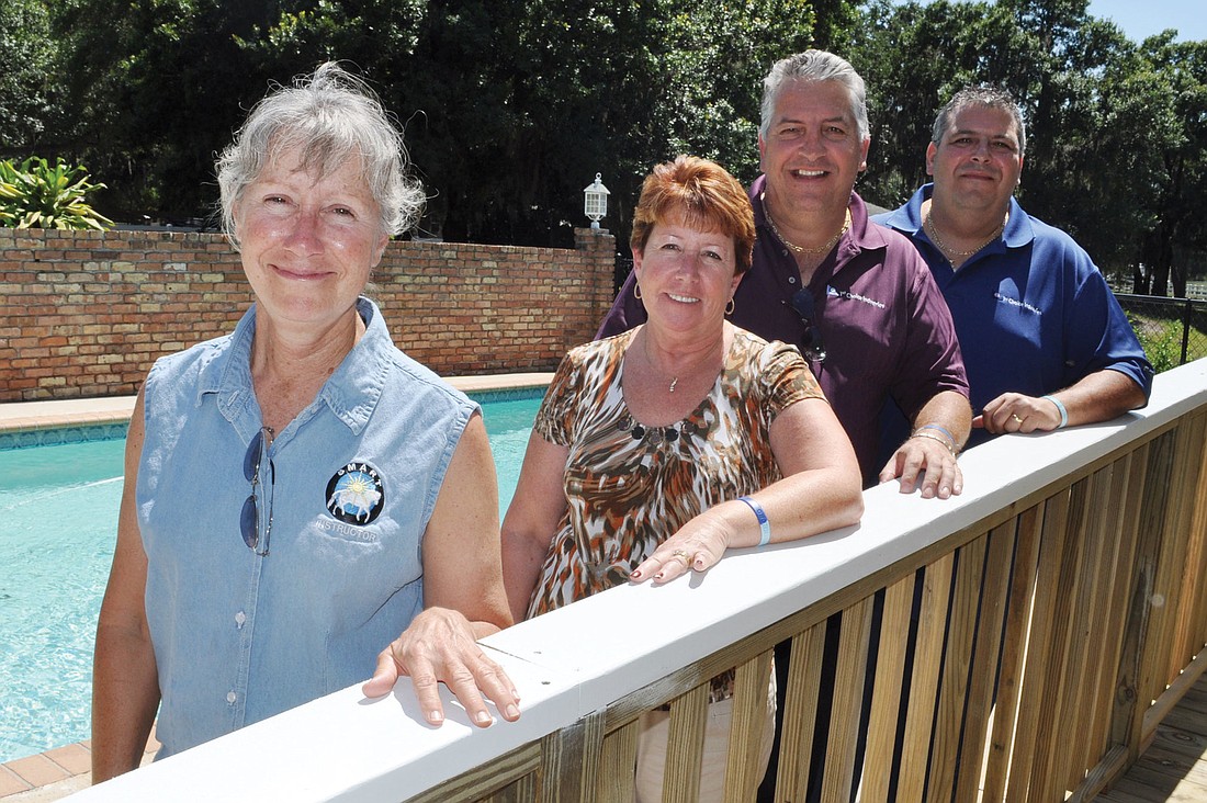 SMART Executive Director Gail Clifton and Eileen, Gary and Darrin Simone, of 1st Choice Industries, stand alongside a newly installed wheelchair ramp by SMARTÃ¢â‚¬â„¢s pool.