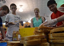 Eight graders Bart Hillerich, Eric Mc Kinnon, senior and table captain Jenny Mooney and eight grader Phillip Tran make sandwiches to break the Guinness World Record.