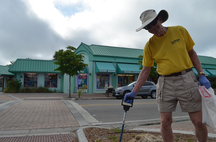 Peter van Roekens picks up trash in the Village.
