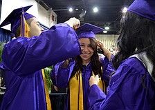 Sergen Altas and Amy Galloza help Camila Alvarado with her cap.
