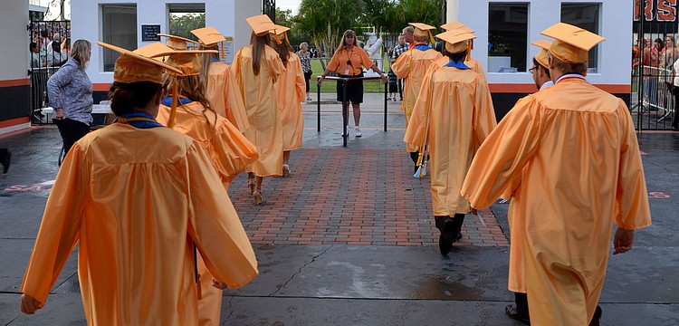 Graduates enter the Sarasota High School football field.