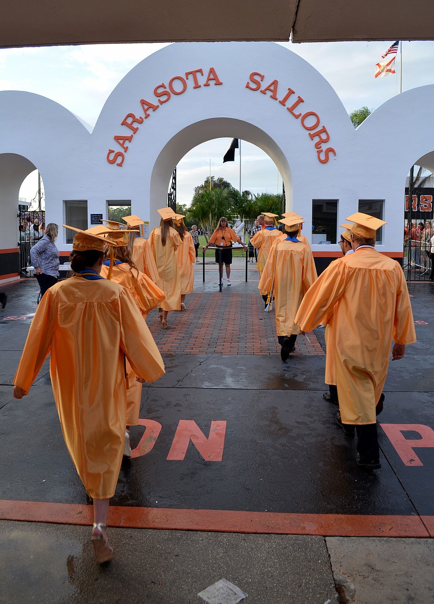 Graduates enter the Sarasota High School football field.