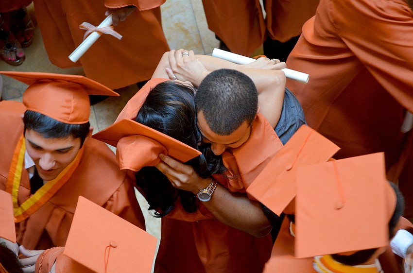 A graduating senior receives a congratulatory hug.