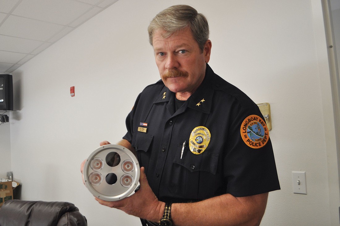 Longboat Key Police Chief Pete Cumming holds one of the cameras, which have a color camera, infrared camera and four illuminators.