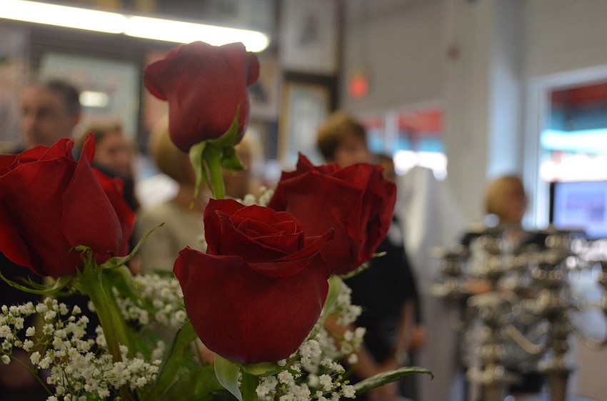 Womenâ€™s Exchange staff placed red roses in vases to display a variation of vases the consignment shop offers.