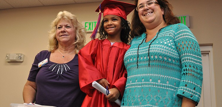 Dereon Lovette center, posed for a picture with her Kiddie Academy teachers, Debbie Frazzoni, left, and Karen Kieran, right, after receiving her diploma.