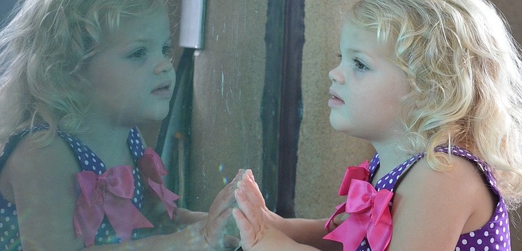 Madison P., 3, observes the sharks swimming overhead.