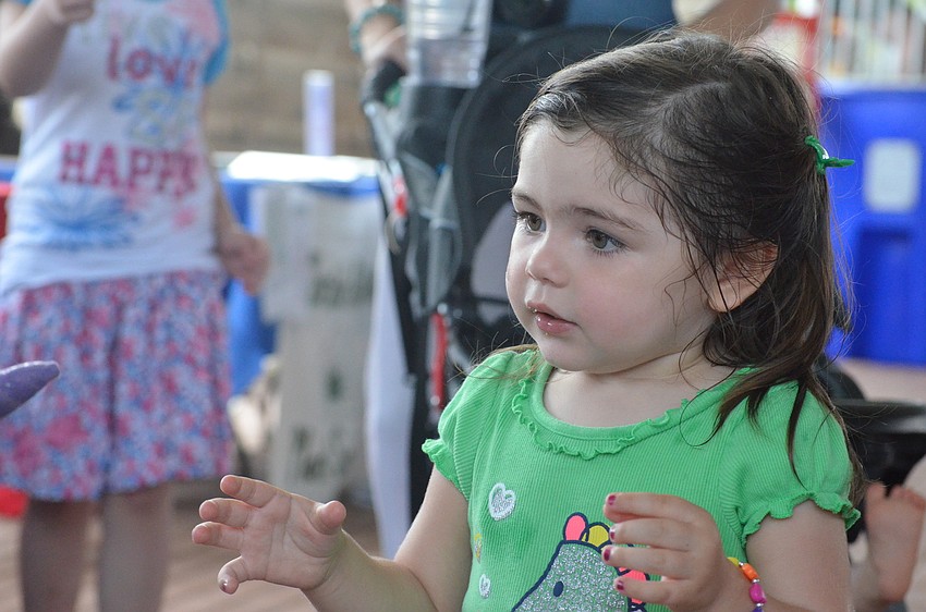 Scarlet Wulf, 2, reaches for a toy.