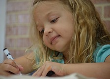 Maggie Layman, 5, colors her Camp Lookout shirt.