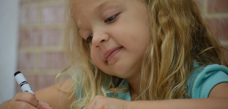 Maggie Layman, 5, colors her Camp Lookout shirt.
