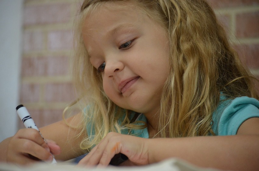 Maggie Layman, 5, colors her Camp Lookout shirt.