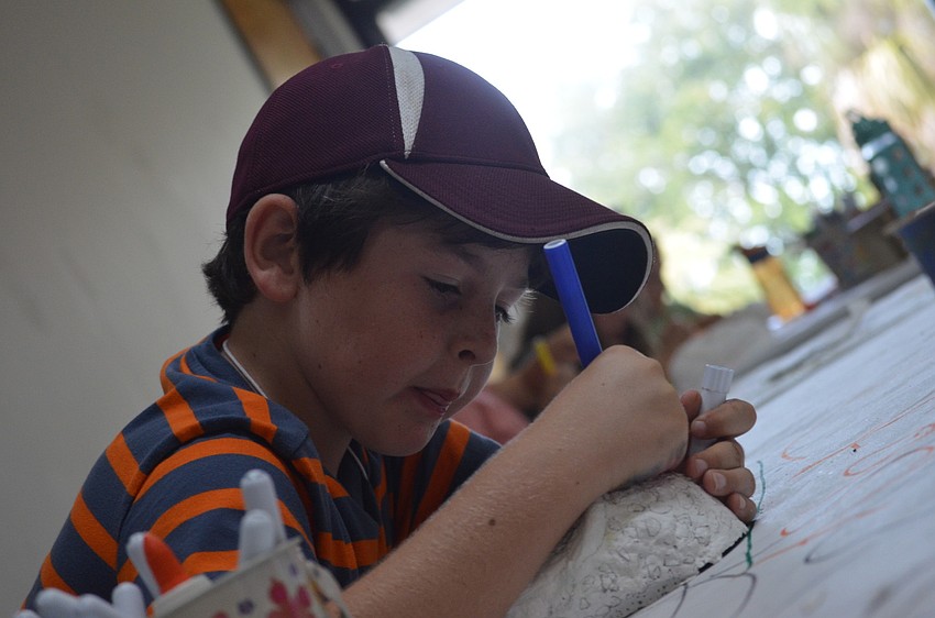 Kique Perales concentrates on coloring his plaster mask.